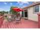 Outdoor deck with metal table and chairs and bright red umbrella, adjacent to sliding glass door at 693 Delwood Ct, Highlands Ranch, CO 80126