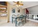 Sunlit dining area featuring seating for four and views of the Gathering room with a red accent wall at 693 Delwood Ct, Highlands Ranch, CO 80126