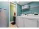 Laundry room featuring modern washer and dryer units with ample shelving at 693 Delwood Ct, Highlands Ranch, CO 80126