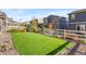 Inviting backyard features artificial turf, a white fence and rock landscaping for low maintenance and aesthetic appeal at 1914 Villageview Ln, Castle Rock, CO 80104