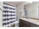 Bathroom with granite countertops, double sinks, tub and shower combo with striped curtain at 1914 Villageview Ln, Castle Rock, CO 80104