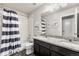 Bathroom featuring double sinks, granite countertops, tub/shower combo with striped curtain at 1914 Villageview Ln, Castle Rock, CO 80104