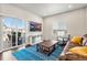 Cozy living room boasts natural light, a comfortable leather couch, and access to an outdoor patio at 1914 Villageview Ln, Castle Rock, CO 80104