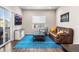 Inviting living room with a modern leather sofa, stylish coffee table, and a bright blue patterned rug at 1914 Villageview Ln, Castle Rock, CO 80104