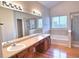 Bright bathroom with double sinks, soaking tub, and separate shower at 13661 Adams St, Thornton, CO 80602