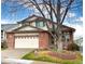 Charming two-story brick home with a well-manicured lawn and a large shade tree in the front yard at 13661 Adams St, Thornton, CO 80602