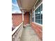 Covered front porch featuring brick siding, white railings, and a view of the neighborhood at 13661 Adams St, Thornton, CO 80602