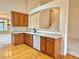 Kitchen features oak cabinetry, wood flooring, a view to the living room and an open view to the staircase at 13661 Adams St, Thornton, CO 80602