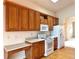 Updated kitchen features oak cabinetry, wood flooring, and modern white appliances at 13661 Adams St, Thornton, CO 80602
