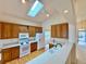Bright kitchen with oak cabinets, white appliances, lots of counter space, skylight, and hardwood floors at 13661 Adams St, Thornton, CO 80602