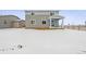 View of the backyard featuring a covered patio and a spacious area covered in snow at 5742 Ranch St, Mead, CO 80504