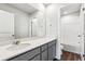 Bathroom featuring a white shower/tub combo, toilet and vanity with gray cabinets and sink and light walls at 5742 Ranch St, Mead, CO 80504