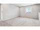 Bright bedroom with neutral carpet, white walls, a window, base trim and several electrical outlets at 5742 Ranch St, Mead, CO 80504