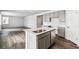 Modern kitchen features an island, stainless steel appliances, gray cabinets, and a sink with a sleek faucet at 5742 Ranch St, Mead, CO 80504