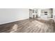 Open-concept living space with wood flooring, flowing into a modern kitchen with gray cabinets and a center island at 5742 Ranch St, Mead, CO 80504