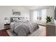 Serene bedroom features a large window, hardwood floors, and a comfortable bed with plush bedding at 12711 Colorado Blvd # 1009, Thornton, CO 80241