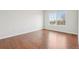 Empty bedroom with hardwood floors, neutral walls, and a bright window at 12711 Colorado Blvd # 1009, Thornton, CO 80241