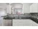 Stylish kitchen with stainless steel dishwasher, mosaic backsplash, and open layout to living area at 12711 Colorado Blvd # 1009, Thornton, CO 80241