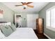 Comfortable bedroom featuring a wooden cabinet, white bedding, and neutral walls at 1675 Newport St, Denver, CO 80220