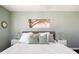 Bright bedroom with a soft green accent wall, white bedding, and hardwood floors at 1675 Newport St, Denver, CO 80220