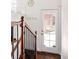 Staircase with wooden rails and black iron spindles, leading to a bright doorway and natural light at 1675 Newport St, Denver, CO 80220