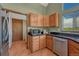 Well-lit kitchen featuring wood cabinets, stainless steel dishwasher, and sleek black countertop at 10534 Inspiration Dr, Parker, CO 80138
