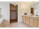Bright bathroom with double sinks, vanity, large mirror, and a closet with sliding doors at 20875 E Girard Pl, Aurora, CO 80013