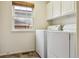 Functional laundry room equipped with modern washer and dryer units and storage cabinets at 20875 E Girard Pl, Aurora, CO 80013