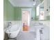 Charming bathroom with a clawfoot tub, pedestal sink, and wainscoting, showcasing classic elegance at 780 N Lafayette St, Denver, CO 80218