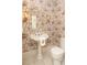 Stylish powder room featuring decorative wallpaper, vintage light fixtures and a pedestal sink at 780 N Lafayette St, Denver, CO 80218