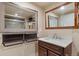 Bathroom vanity with brown cabinets, white countertop and sink, and decorative framed mirrors at 12940 Jasmine St # A, Thornton, CO 80602