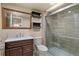 Tastefully updated bathroom with modern vanity, framed mirror, shelving, and glass-enclosed shower at 12940 Jasmine St # A, Thornton, CO 80602