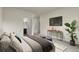 Comfortable bedroom featuring soft lighting, modern decor, and a doorway to the ensuite bath at 12940 Jasmine St # A, Thornton, CO 80602