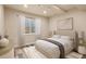Bright bedroom with a large window, neutral decor, wood-look floors, and a comfortable bed at 12940 Jasmine St # A, Thornton, CO 80602