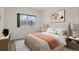 Bright bedroom with neutral decor, a cozy bed, and a large window overlooking the neighborhood at 12940 Jasmine St # A, Thornton, CO 80602