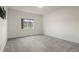 Bright bedroom featuring neutral carpeting, a window, and fresh, clean walls at 12940 Jasmine St # A, Thornton, CO 80602