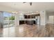 Bright open floor plan featuring hardwood floors, ceiling fan, and a view into the modern kitchen with stainless steel appliances at 12940 Jasmine St # A, Thornton, CO 80602