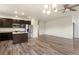 Bright open floor plan featuring hardwood floors, ceiling fan, and a view into the modern kitchen at 12940 Jasmine St # A, Thornton, CO 80602