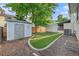 Landscaped backyard featuring a shed, manicured lawn, and gravel accents at 11978 W Aqueduct Dr, Littleton, CO 80127