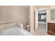 Bathroom with a soaking tub and adjacent bedroom, offering comfort and convenience at 11978 W Aqueduct Dr, Littleton, CO 80127