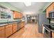 Open-concept kitchen with stainless appliances, wood cabinets, and a view into the living area with a fireplace at 11978 W Aqueduct Dr, Littleton, CO 80127