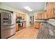 Well-lit kitchen with stainless steel appliances, hardwood floors, and views to the dining room at 11978 W Aqueduct Dr, Littleton, CO 80127