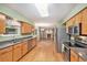 Bright kitchen with stainless appliances, wood cabinets, and a view into the living area with a fireplace at 11978 W Aqueduct Dr, Littleton, CO 80127
