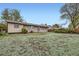 Wide shot of the back exterior and backyard, featuring a spacious lawn, wood fence and patio at 9134 Bellaire St, Thornton, CO 80229