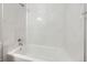 Close-up of the shower-over-tub with shiny chrome fixtures and bright white marble-look tile surround at 9134 Bellaire St, Thornton, CO 80229