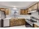Well-lit kitchen with dark wood cabinets, modern appliances, and ample counter space at 9134 Bellaire St, Thornton, CO 80229