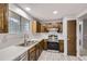 Modern kitchen with dark wood cabinets, stainless steel appliances, and bright countertops at 9134 Bellaire St, Thornton, CO 80229