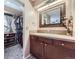 Bathroom featuring vanity with granite countertop, decorative mirror, and access to walk-in closet at 8210 Hoyt Ct, Arvada, CO 80005