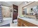 Bathroom features a tiled shower-tub, granite counters, and a large mirror at 8210 Hoyt Ct, Arvada, CO 80005