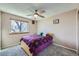 Cozy bedroom features plush gray carpeting, natural light, and a ceiling fan at 8210 Hoyt Ct, Arvada, CO 80005